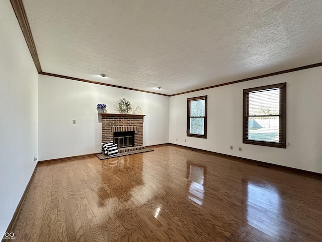 unfurnished living room with a fireplace, crown molding, wood finished floors, and a textured ceiling