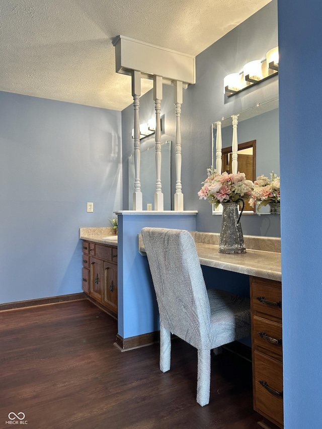 bathroom featuring vanity, wood finished floors, baseboards, and a textured ceiling