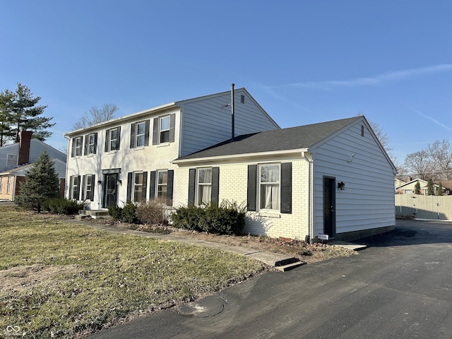 colonial home featuring brick siding