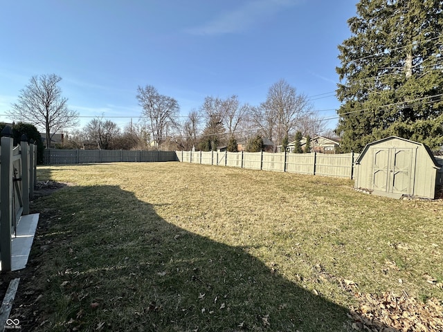 view of yard with an outbuilding, a fenced backyard, and a shed