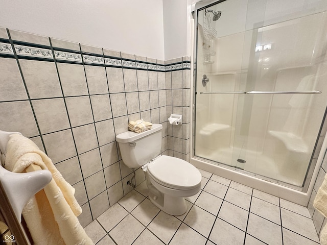 bathroom featuring tile patterned flooring, a shower stall, and toilet