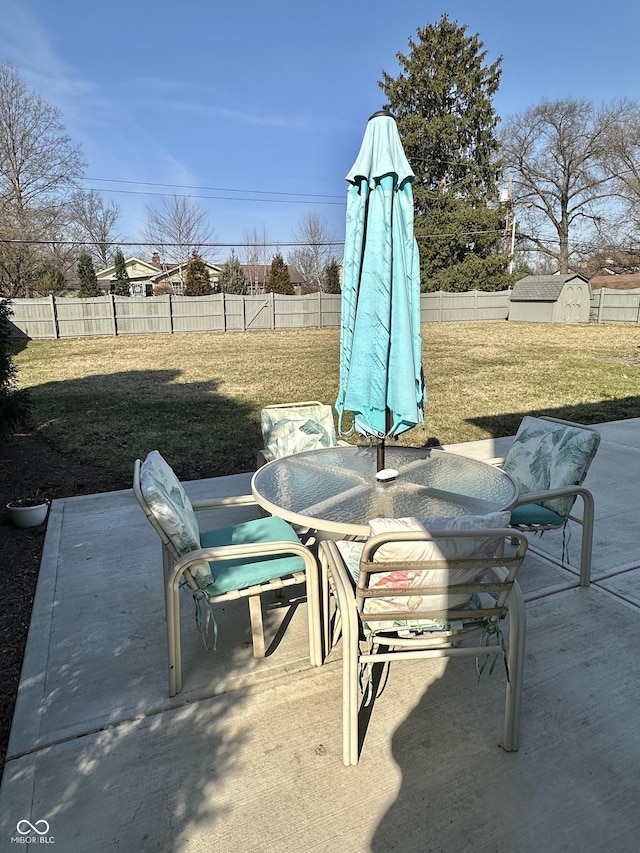 view of patio with an outbuilding, a storage unit, and a fenced backyard