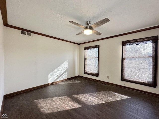 spare room featuring crown molding, wood finished floors, visible vents, and ceiling fan