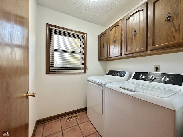 washroom featuring visible vents, independent washer and dryer, a textured ceiling, cabinet space, and light tile patterned floors