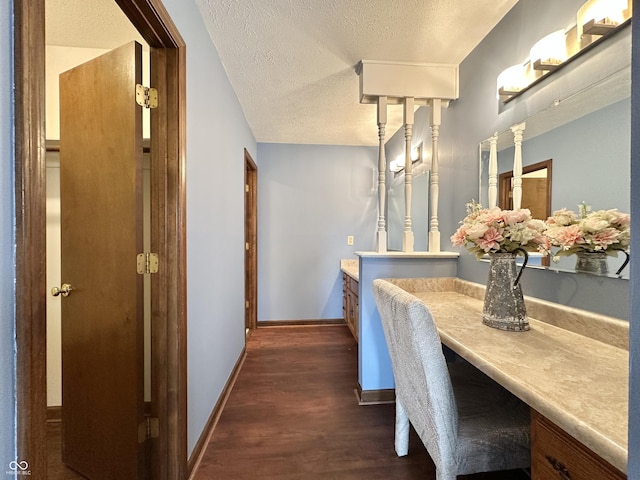 bathroom featuring vanity, wood finished floors, baseboards, and a textured ceiling