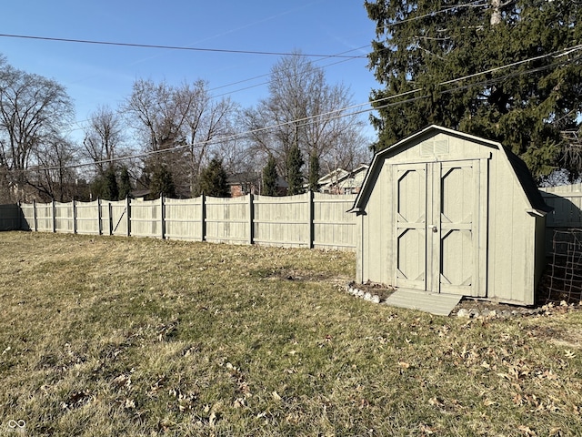 view of yard featuring an outdoor structure, a fenced backyard, and a shed