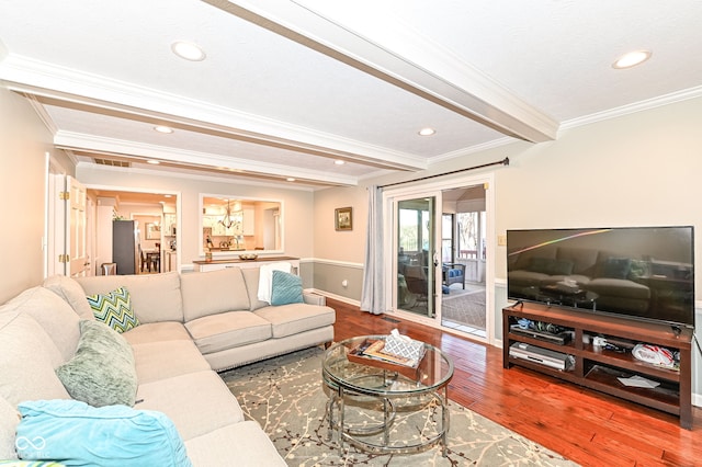 living area featuring wood finished floors, baseboards, beam ceiling, recessed lighting, and ornamental molding