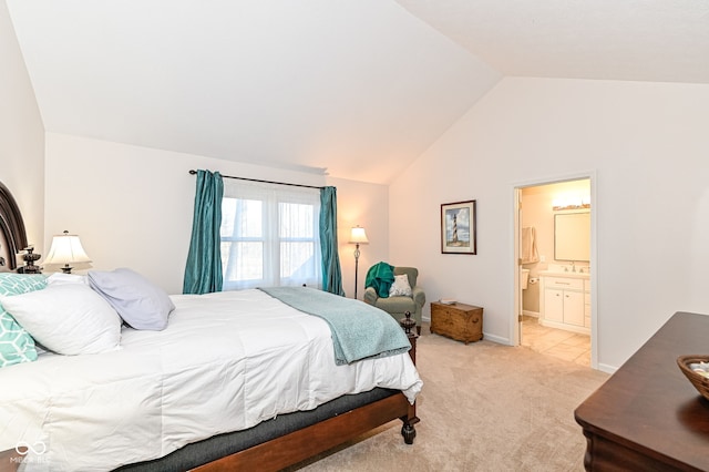 bedroom with light carpet, lofted ceiling, a sink, ensuite bath, and baseboards