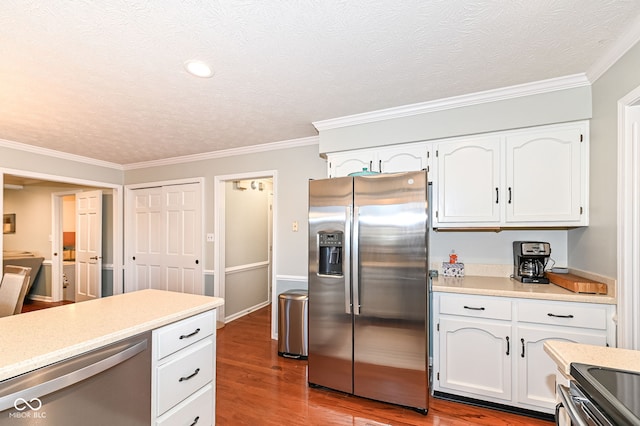 kitchen featuring stainless steel appliances, wood finished floors, light countertops, and white cabinetry