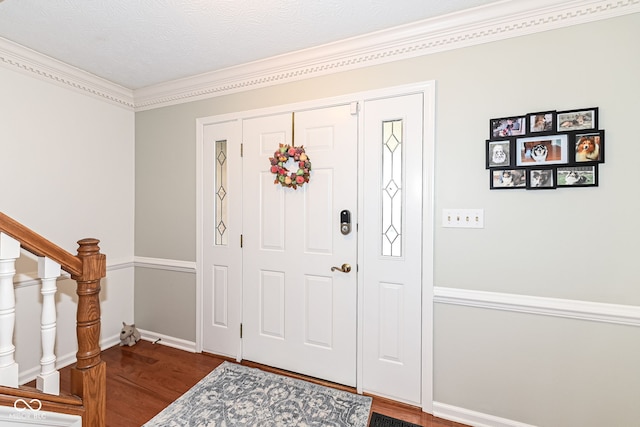 foyer with baseboards, wood finished floors, and stairs