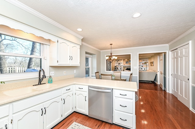 kitchen featuring a peninsula, a sink, white cabinets, dishwasher, and a notable chandelier