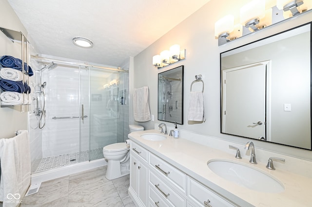 bathroom featuring a stall shower, marble finish floor, and a sink