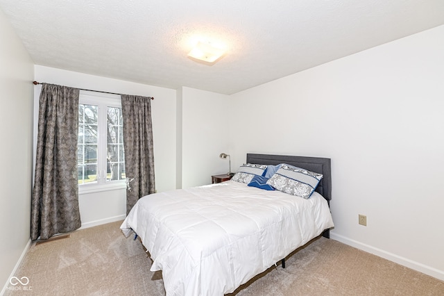 carpeted bedroom with baseboards and a textured ceiling