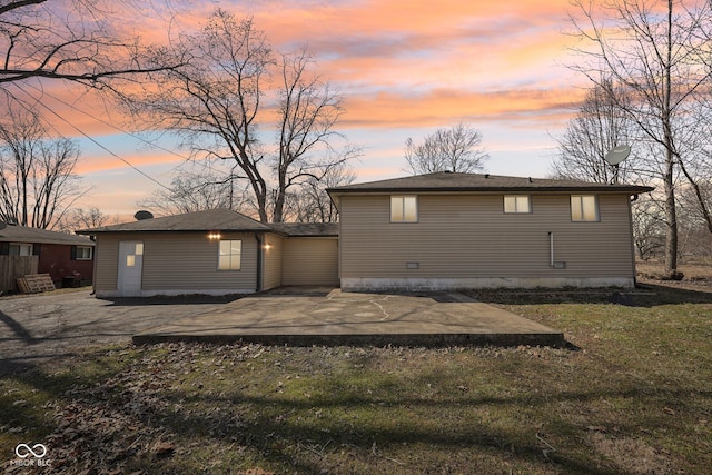 rear view of property featuring a patio and a lawn