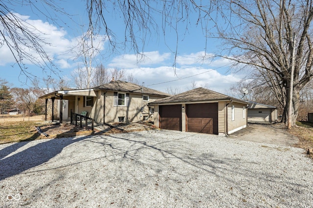 view of front of home featuring a detached garage, an outdoor structure, and roof with shingles