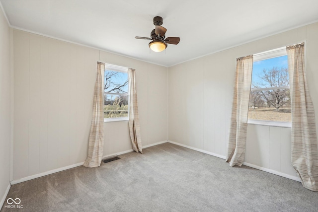 unfurnished room with visible vents, ceiling fan, and carpet