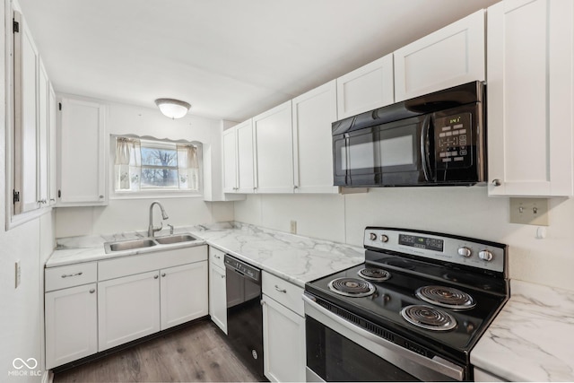 kitchen with black appliances, a sink, light stone counters, wood finished floors, and white cabinets