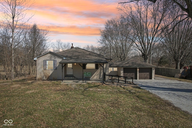 view of front of property with a front lawn, a detached garage, an outdoor structure, and fence