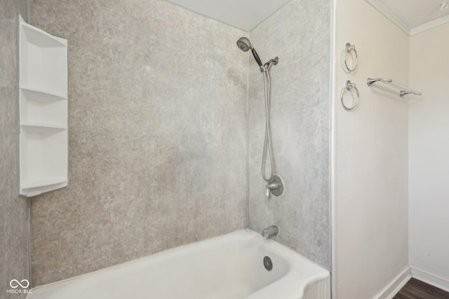 bathroom featuring shower / bathing tub combination, baseboards, and ornamental molding