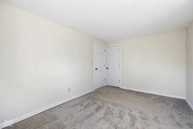 carpeted empty room featuring baseboards