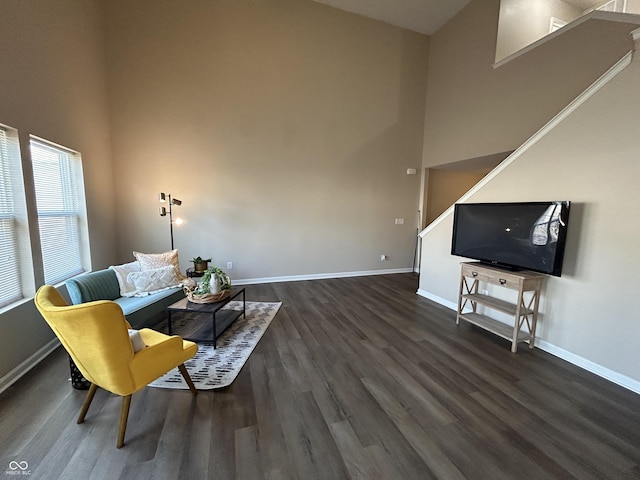 sitting room featuring a high ceiling, wood finished floors, and baseboards