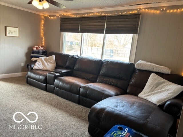 living room featuring crown molding, baseboards, carpet, a textured ceiling, and a ceiling fan