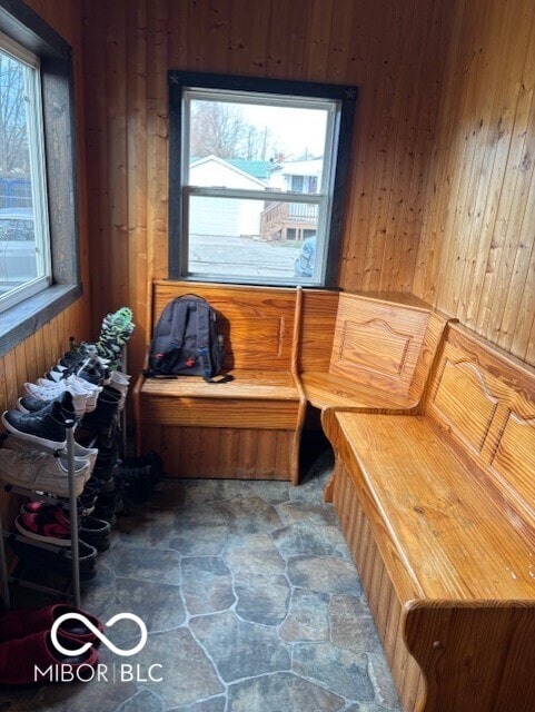 miscellaneous room featuring wooden walls and stone finish floor