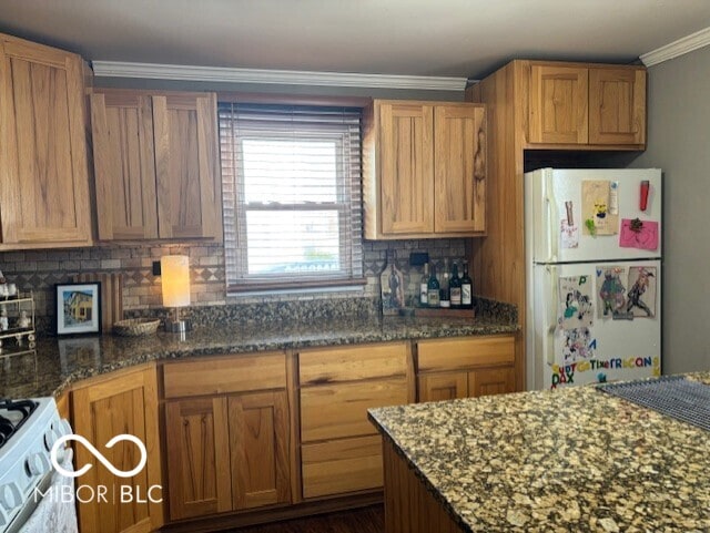 kitchen featuring tasteful backsplash, dark stone countertops, white appliances, and crown molding