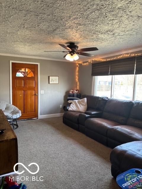 living room featuring ornamental molding, a textured ceiling, carpet, baseboards, and ceiling fan