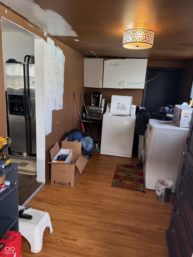 kitchen featuring stainless steel fridge, white cabinets, and wood finished floors