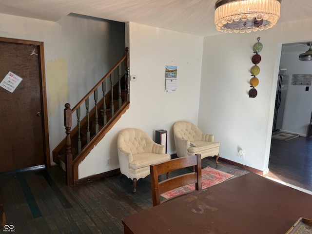 sitting room featuring a chandelier, stairway, baseboards, and hardwood / wood-style flooring