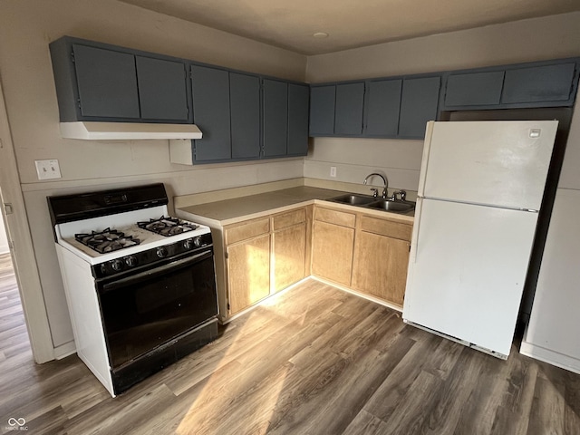 kitchen featuring range with gas stovetop, wood finished floors, freestanding refrigerator, a sink, and under cabinet range hood