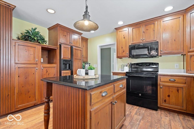 kitchen featuring black appliances, recessed lighting, light wood finished floors, and a kitchen island