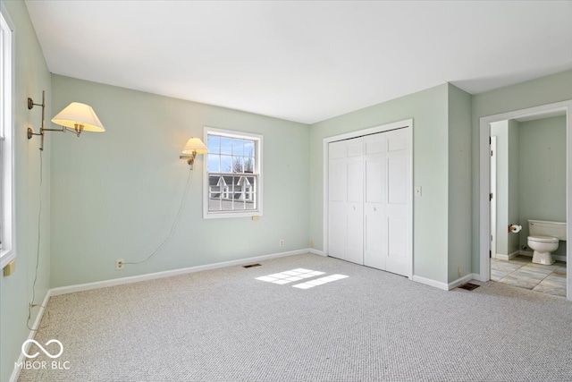 unfurnished bedroom featuring a closet, baseboards, visible vents, and carpet floors