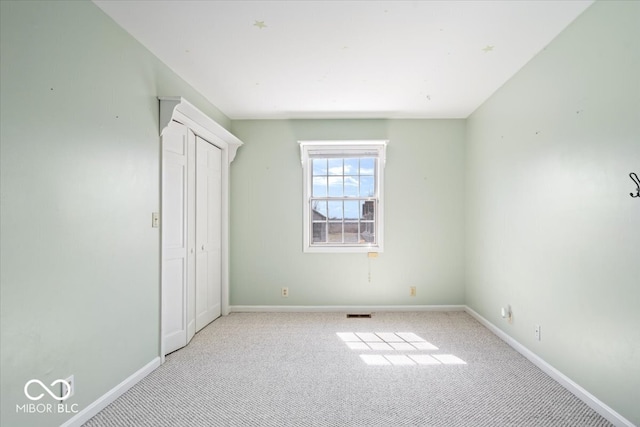 unfurnished bedroom featuring carpet flooring, baseboards, and a closet