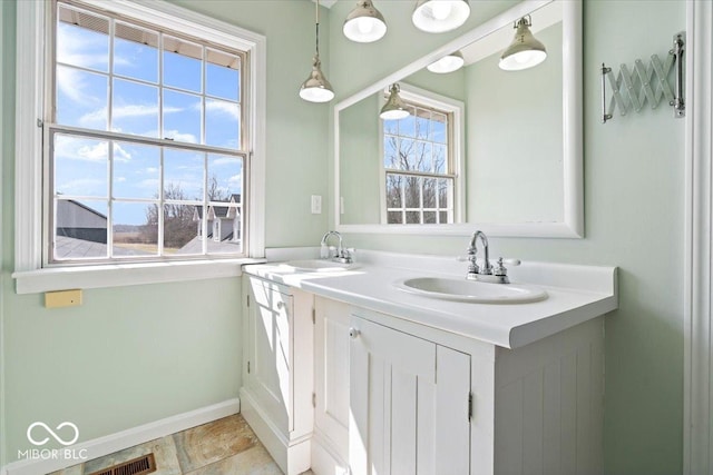 bathroom featuring visible vents, baseboards, and vanity