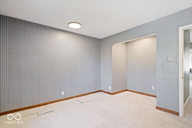 carpeted empty room featuring baseboards