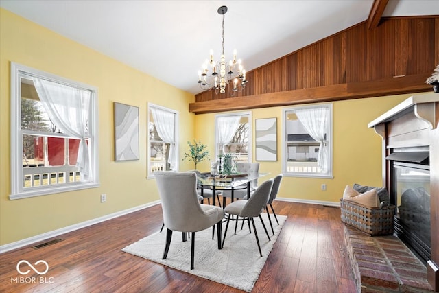 dining space featuring vaulted ceiling, a notable chandelier, visible vents, and dark wood-style flooring