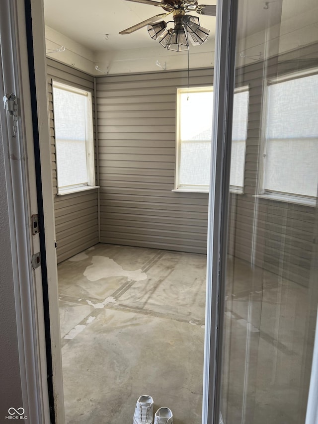 spare room featuring a ceiling fan, concrete floors, and a wealth of natural light