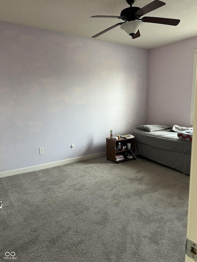 unfurnished bedroom featuring a textured ceiling, baseboards, and carpet floors