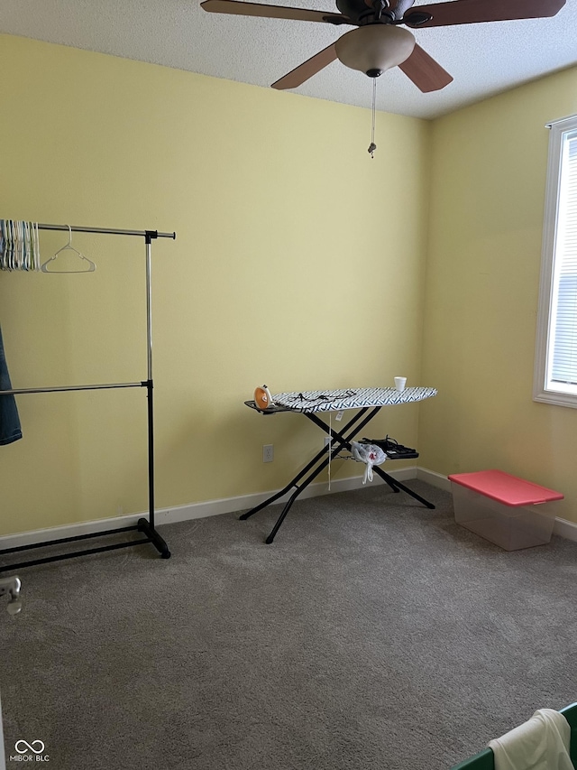 workout area featuring baseboards, carpet, and ceiling fan