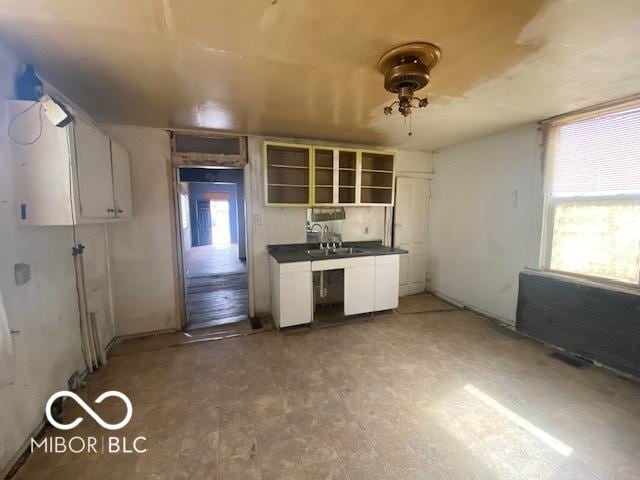 kitchen with tile patterned floors, open shelves, dark countertops, white cabinets, and ceiling fan