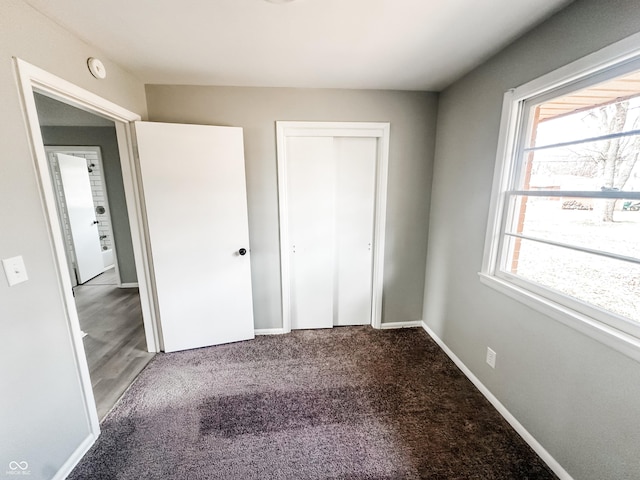 unfurnished bedroom with a closet, baseboards, and carpet floors