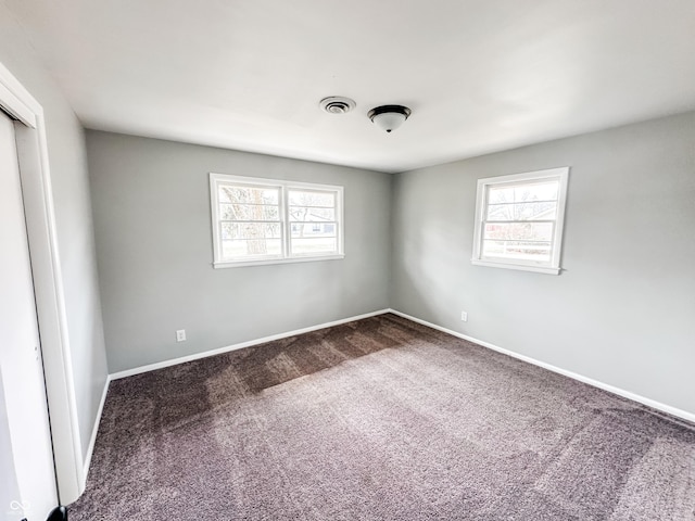 carpeted empty room with visible vents and baseboards