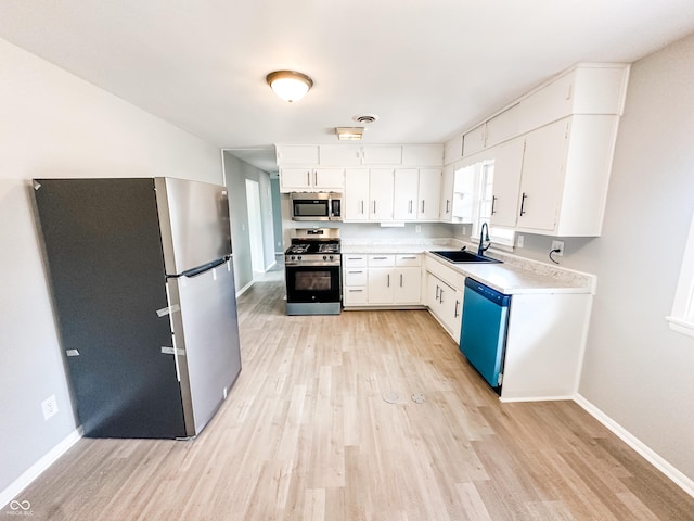 kitchen featuring a sink, light wood-type flooring, appliances with stainless steel finishes, and light countertops