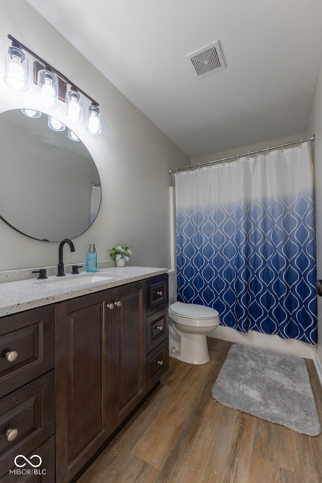 bathroom with vanity, wood finished floors, visible vents, curtained shower, and toilet