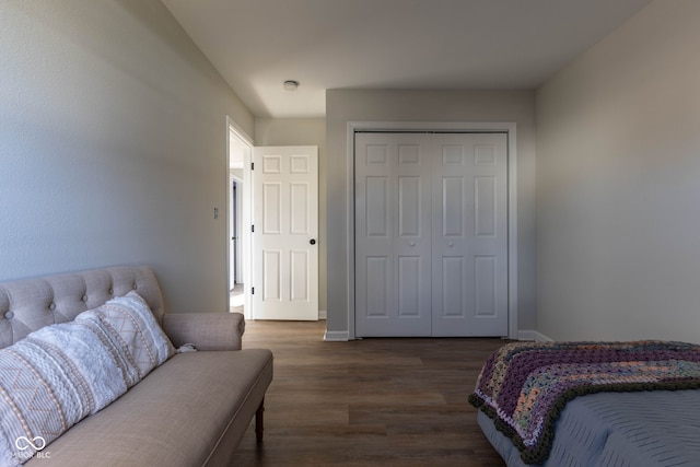 bedroom with baseboards, dark wood-style flooring, and a closet