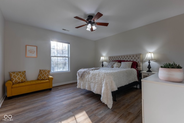 bedroom with visible vents, ceiling fan, baseboards, and wood finished floors