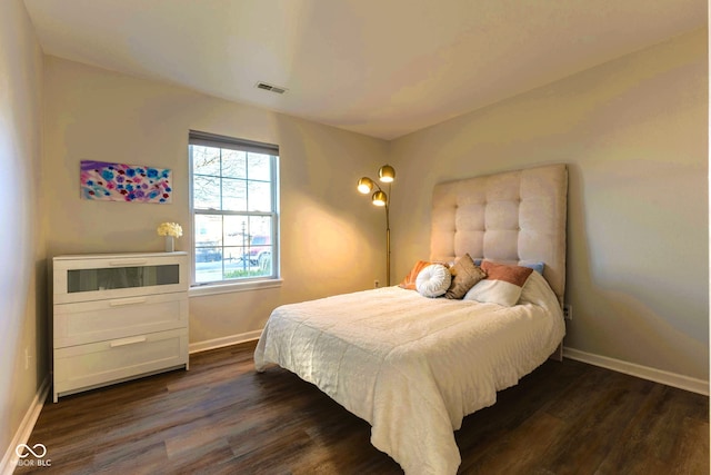 bedroom featuring visible vents, baseboards, and dark wood-style flooring