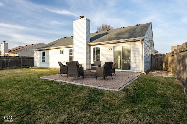 rear view of house with a fenced backyard, a chimney, a patio area, a lawn, and an outdoor hangout area